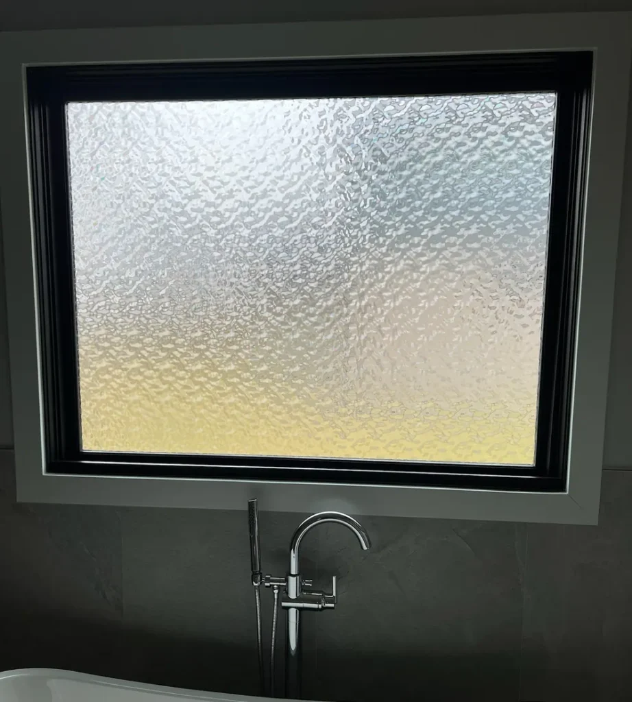 Frosted privacy window film on a bathroom window above a freestanding tub in St. John, IN