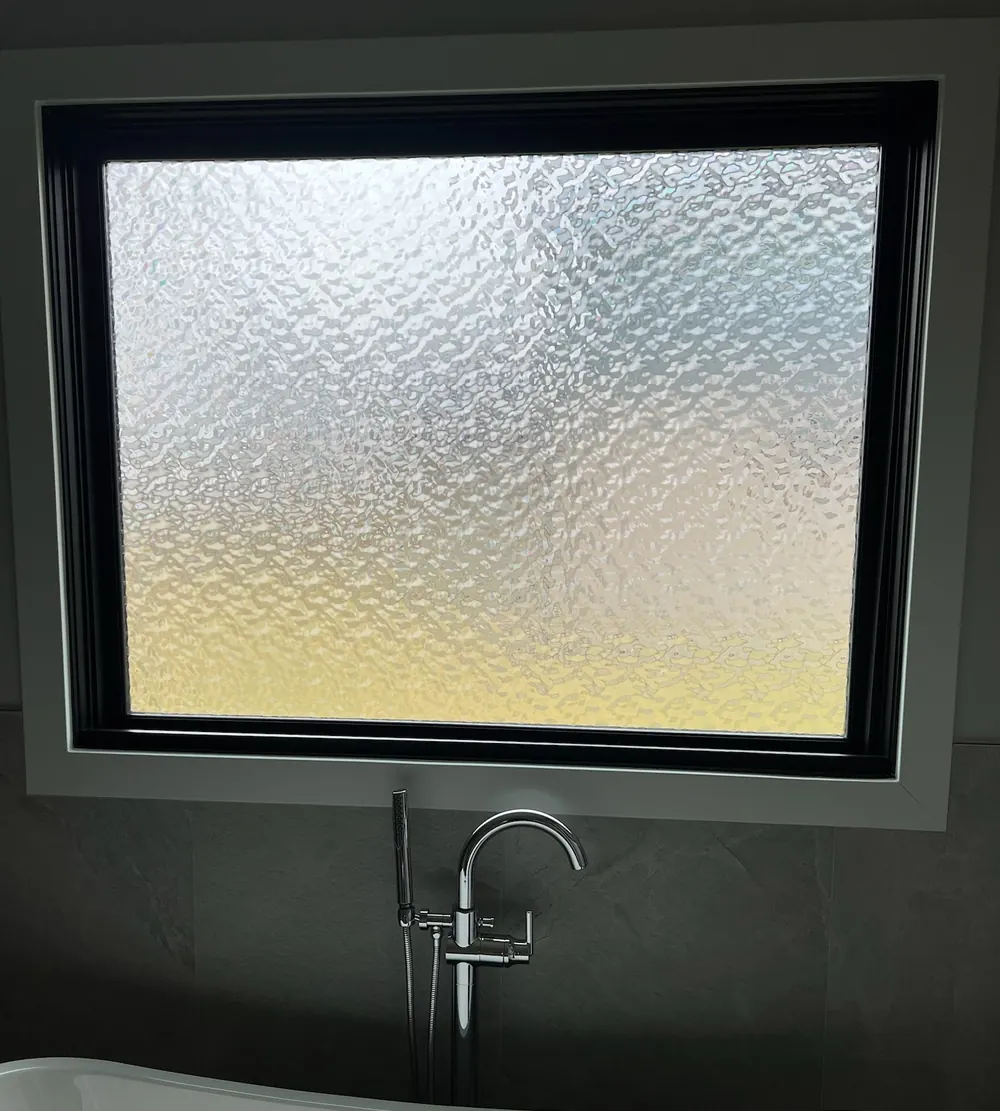 Frosted privacy window film on a bathroom window above a freestanding tub in St. John, IN