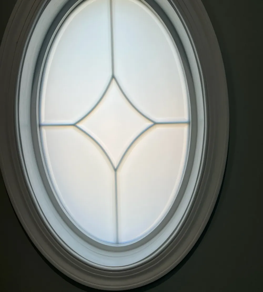 Frosted decorative film on an oval window with a diamond grille in St. John, IN