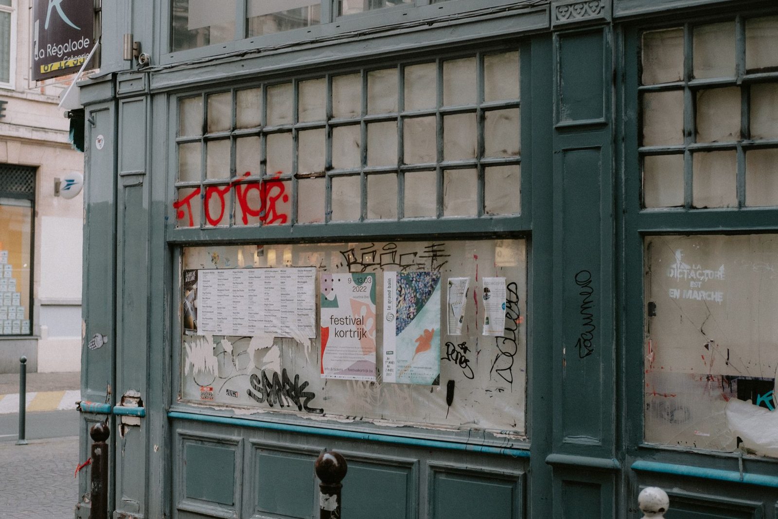 Storefront windows covered in graffiti tags and stickers