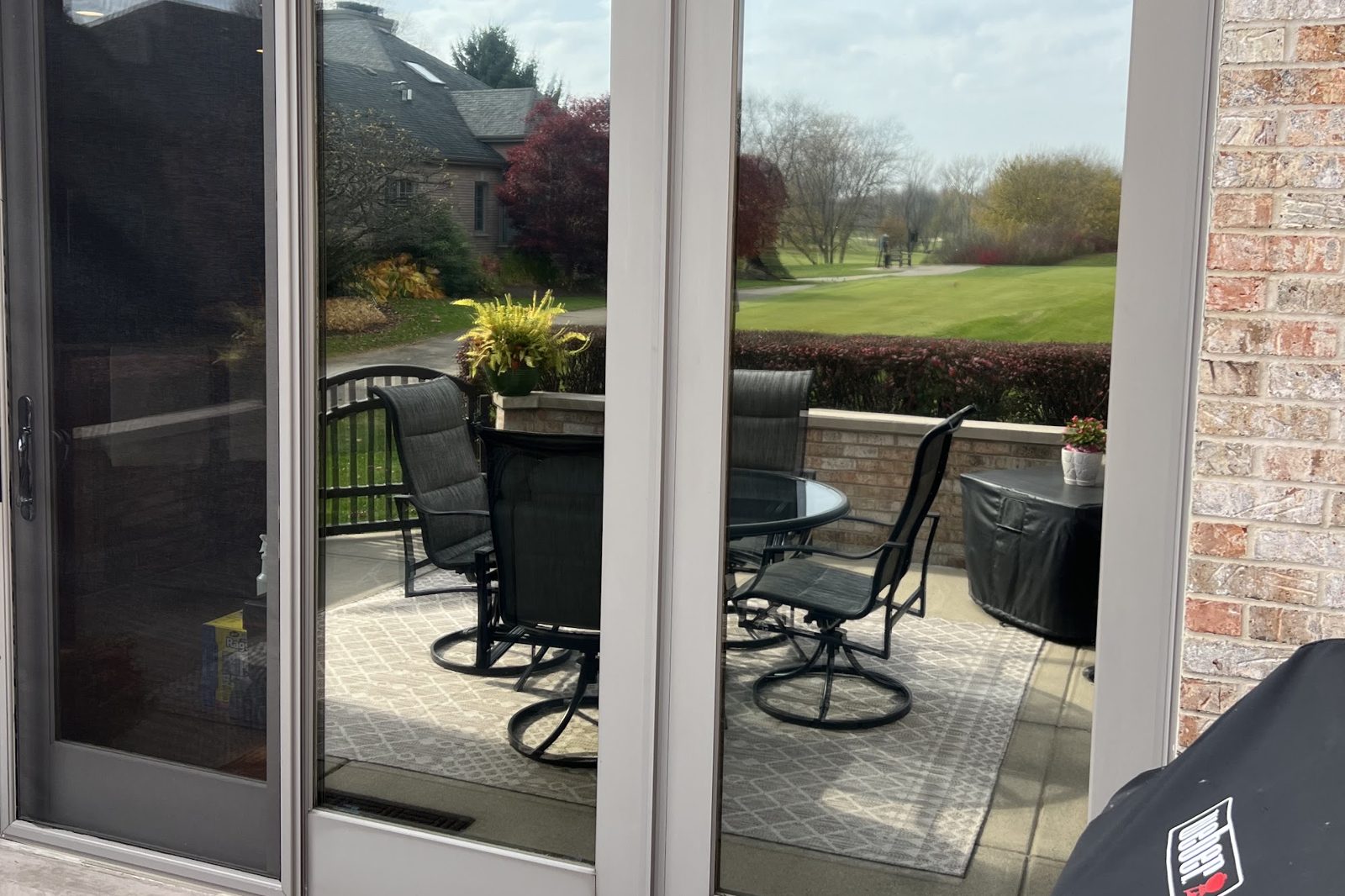 Sliding patio doors with reflective window film on a brick home