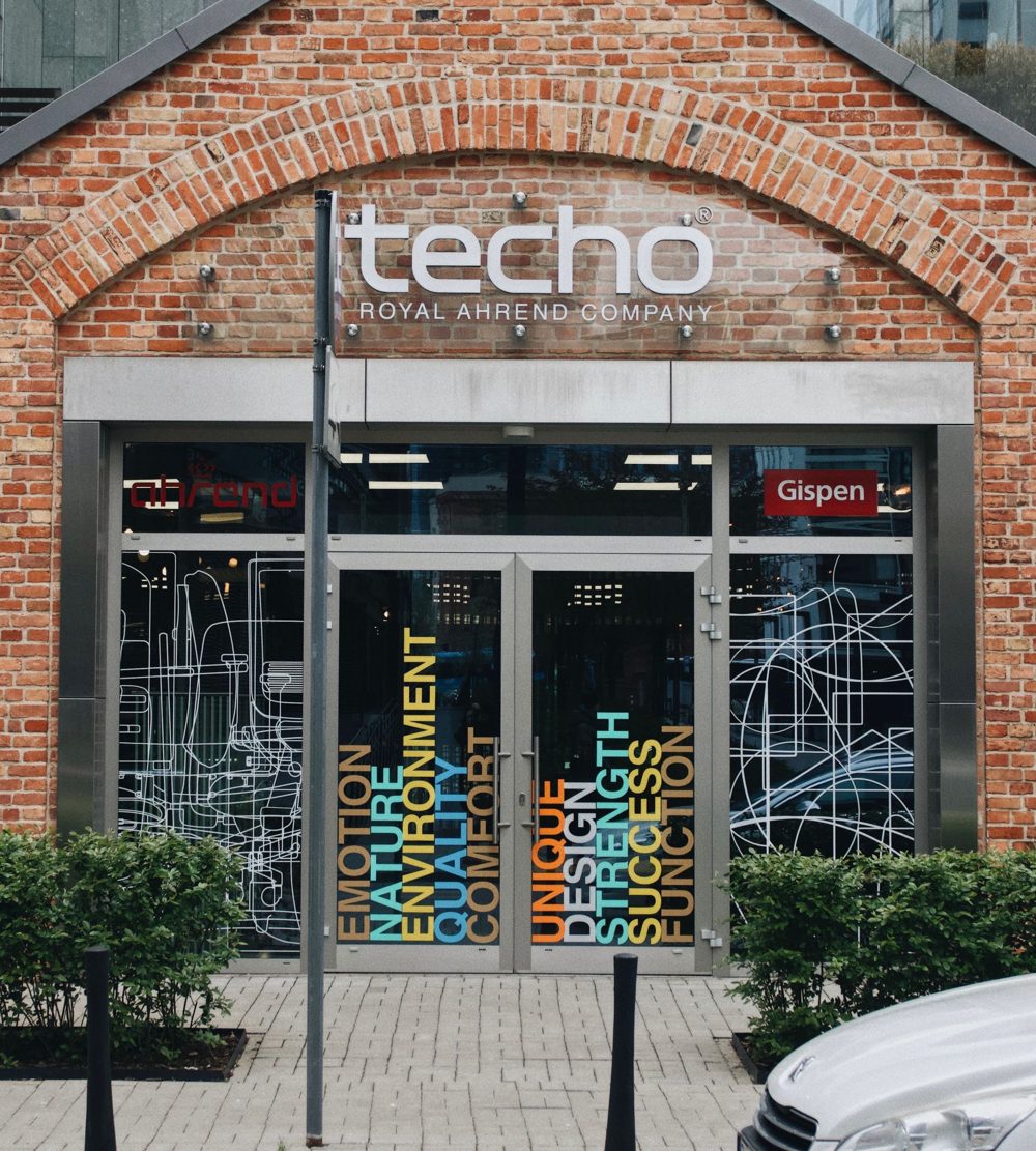 Brick storefront with colourful vinyl window graphics on the glass doors