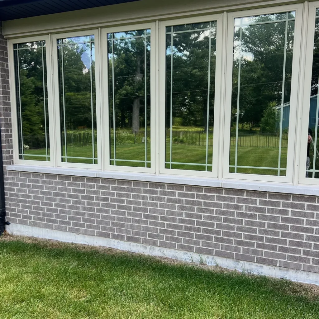 Row of sunroom windows on a brick home after window film installation in St. John, IN